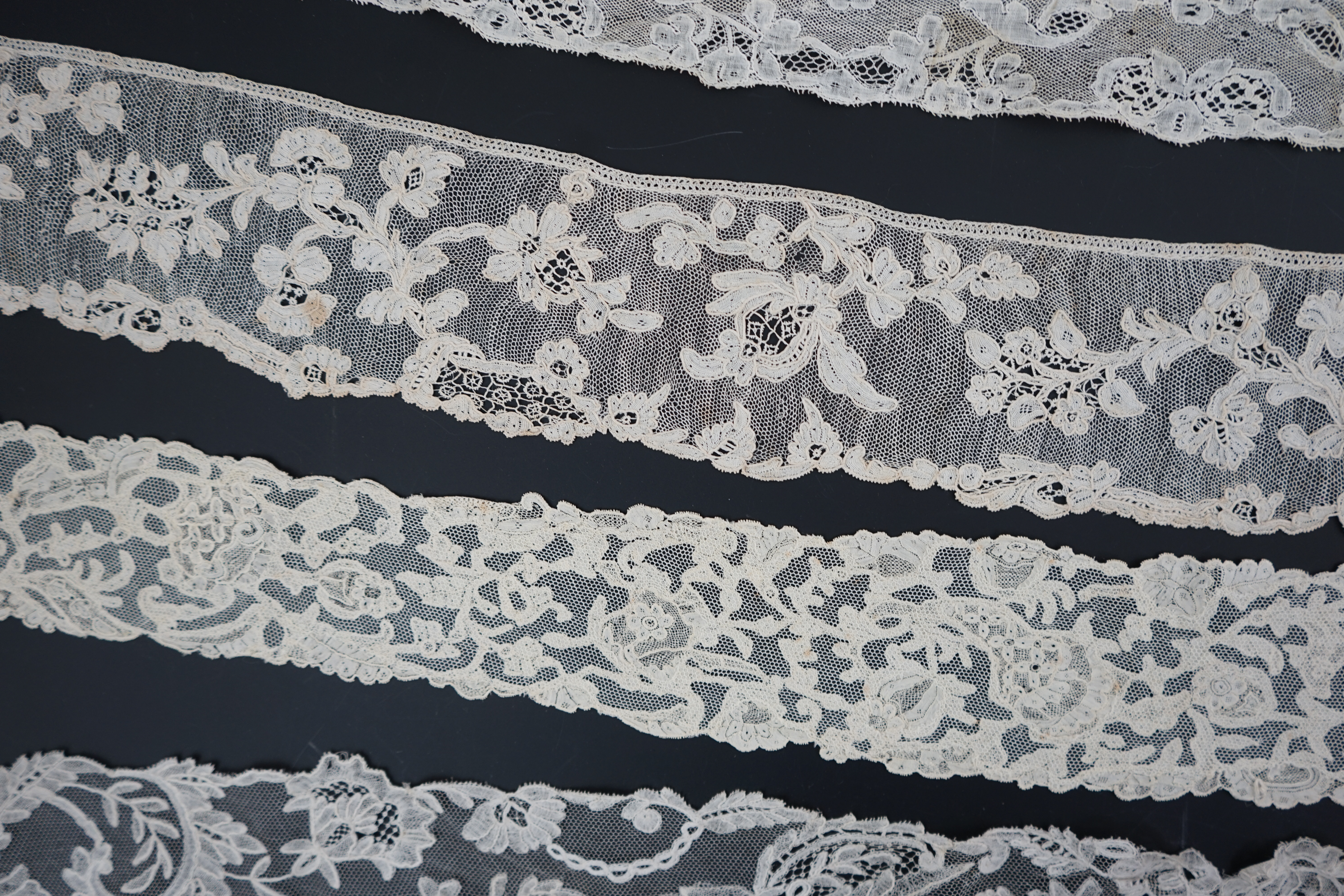 A large section of an ornate 19th century Brussels bobbin lace wedding veil, with two finished edges and one cut edge together with 18th century and later needle lace, an Argentan and an Alencon trimming, possibly an 18t